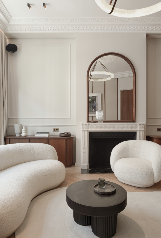 Cheminée en marbre noir, miroir arche noyer, canapés bouclette